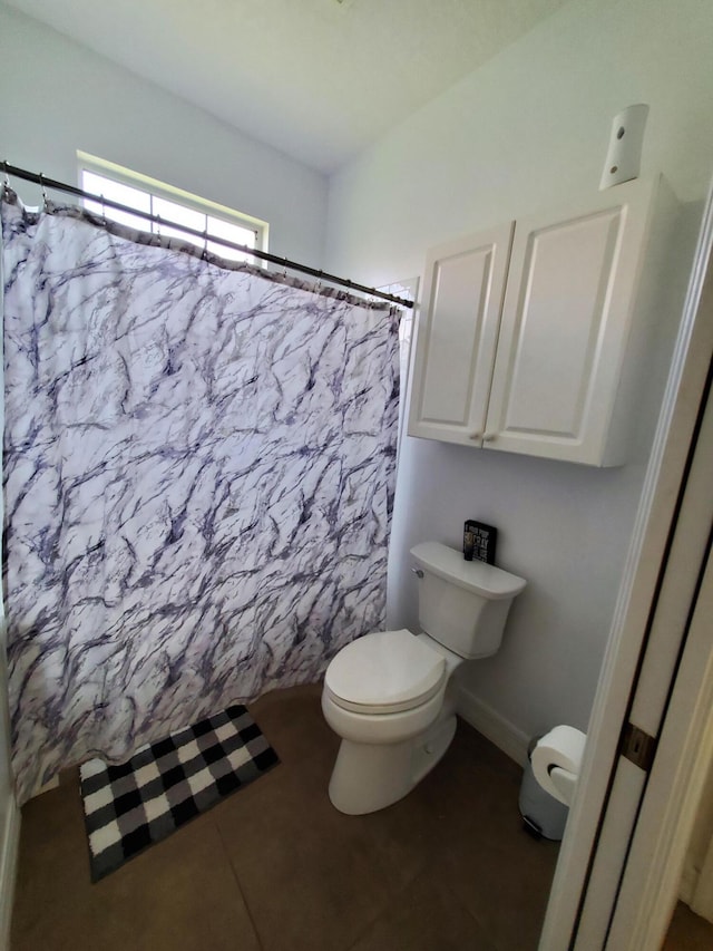 bathroom featuring toilet, tile patterned flooring, and a shower with shower curtain