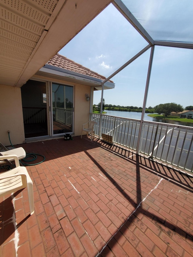 view of patio / terrace with a water view and glass enclosure