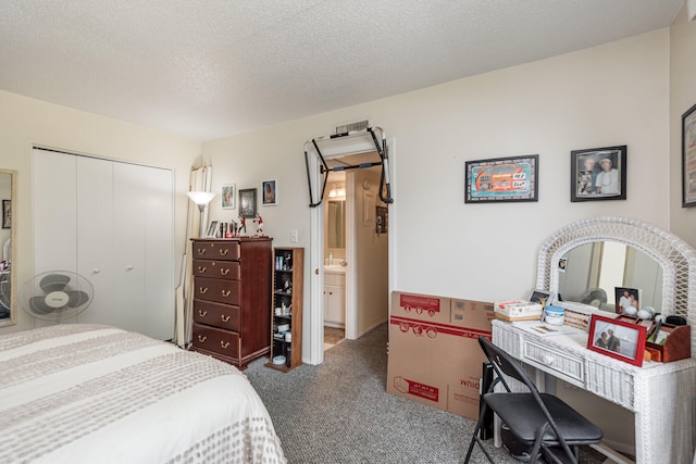 carpeted bedroom with a textured ceiling and a closet