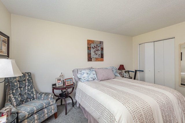 carpeted bedroom with a textured ceiling and a closet