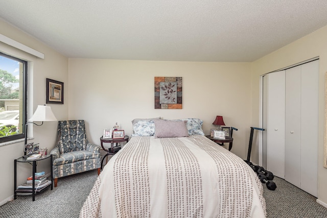 carpeted bedroom featuring a textured ceiling and a closet