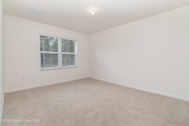 unfurnished room featuring light carpet