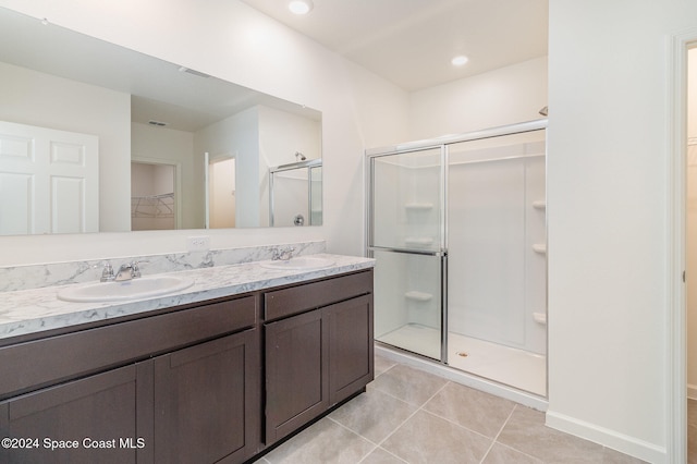 bathroom featuring tile patterned flooring, vanity, and a shower with shower door