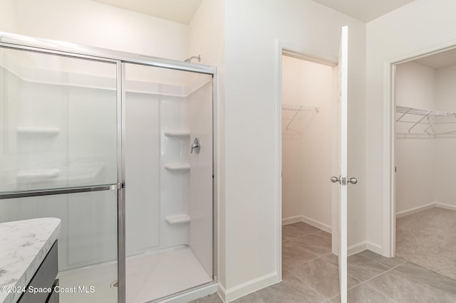 bathroom with vanity, tile patterned floors, and a shower with door