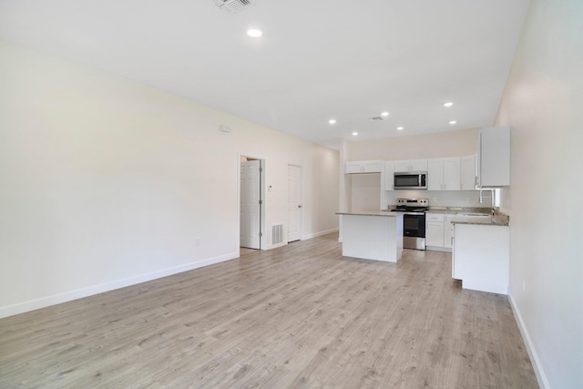 kitchen featuring light hardwood / wood-style flooring, stainless steel appliances, white cabinetry, a center island, and sink