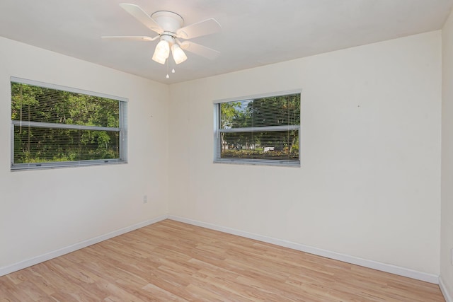 empty room with a wealth of natural light, ceiling fan, and light wood-type flooring