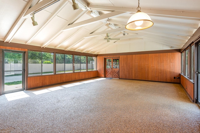 unfurnished sunroom featuring ceiling fan, rail lighting, and lofted ceiling with beams