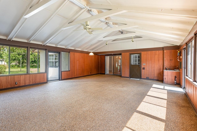 unfurnished sunroom featuring lofted ceiling with beams