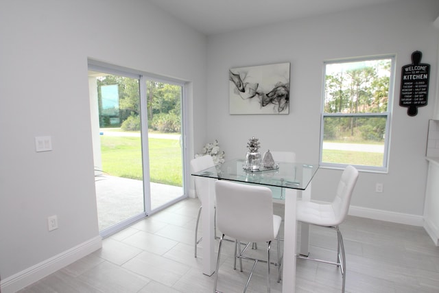 tiled dining space featuring plenty of natural light