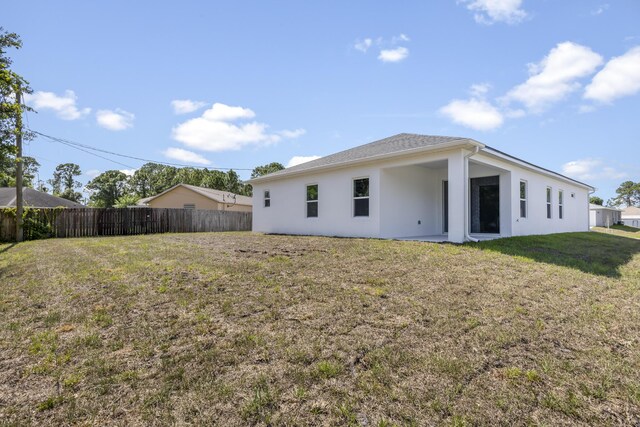 back of property featuring a yard