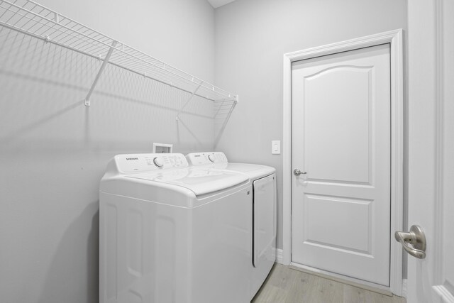 washroom featuring light hardwood / wood-style floors and washing machine and dryer