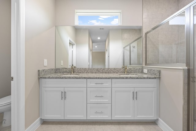 bathroom featuring vanity, a shower with shower door, and toilet