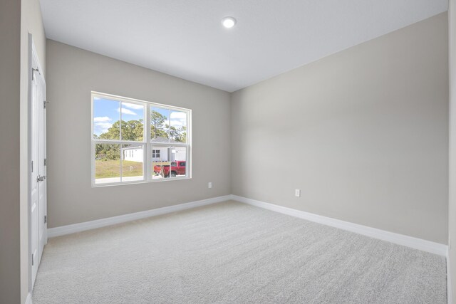 unfurnished room featuring light carpet