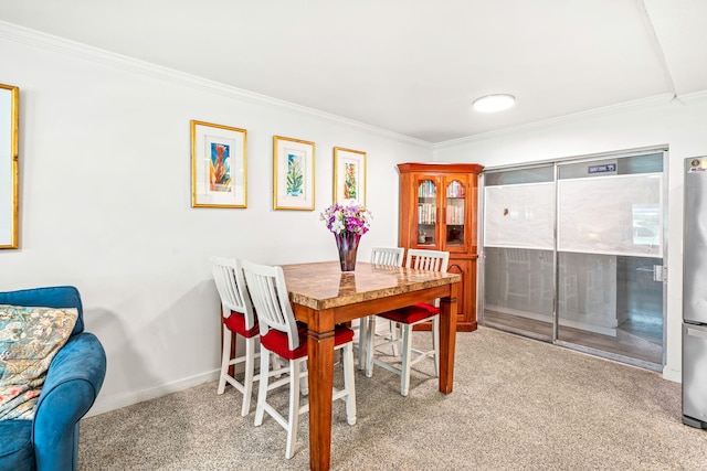 dining area with light colored carpet and ornamental molding