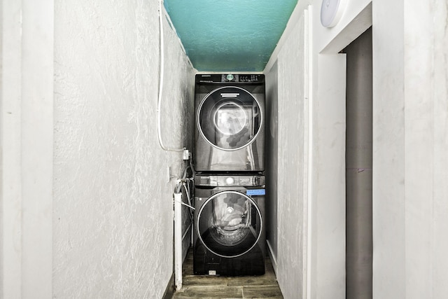 laundry area featuring hardwood / wood-style flooring and stacked washer / dryer