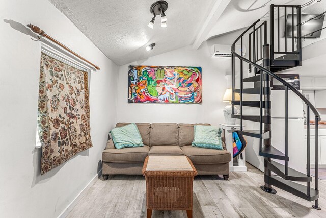 living room with a wall unit AC, lofted ceiling with beams, wood-type flooring, and a textured ceiling