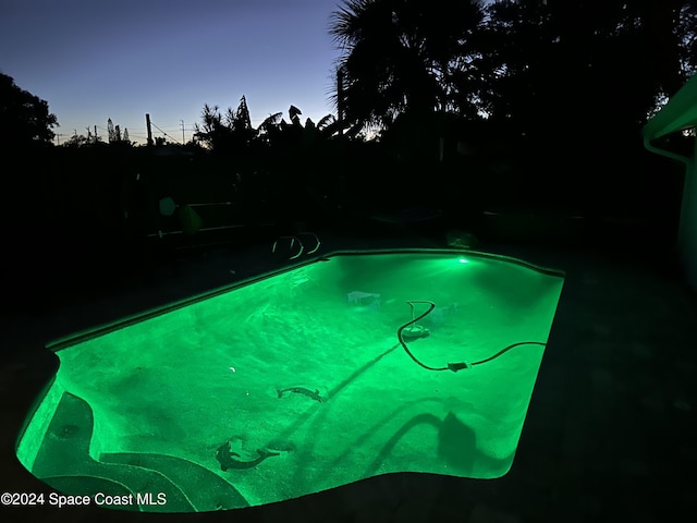 view of pool at dusk