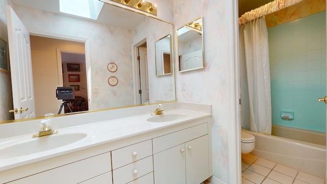 full bathroom with a skylight, tile patterned floors, vanity, shower / bathtub combination with curtain, and toilet