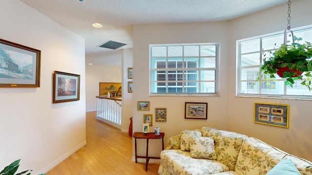 interior space featuring light wood-type flooring and a textured ceiling