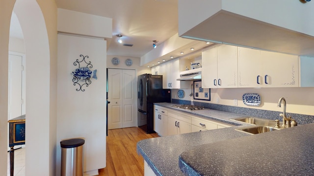 kitchen with stainless steel gas stovetop, light wood-type flooring, white cabinetry, and sink