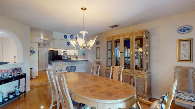 dining room with a chandelier and light hardwood / wood-style flooring