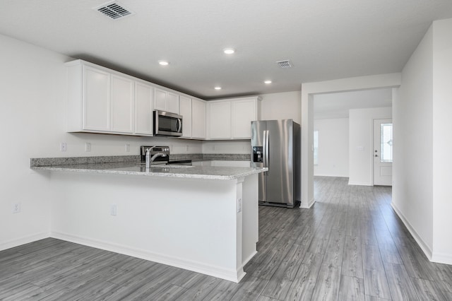 kitchen with white cabinets, sink, light hardwood / wood-style flooring, kitchen peninsula, and stainless steel appliances