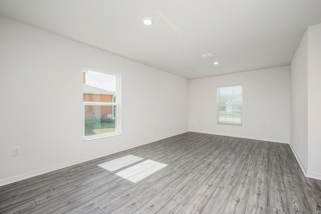 unfurnished room with hardwood / wood-style flooring and a healthy amount of sunlight