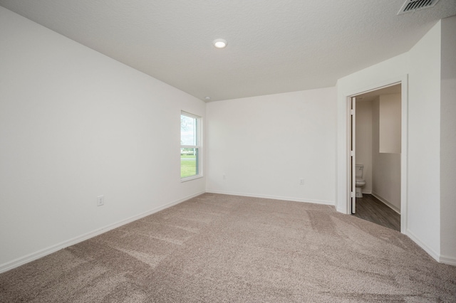 unfurnished room featuring carpet flooring and a textured ceiling