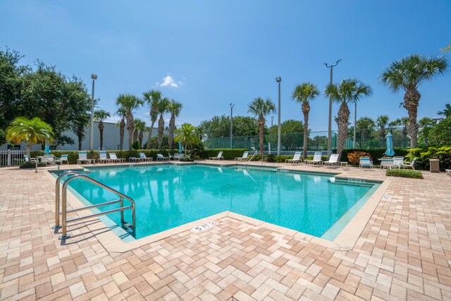 pool featuring fence and a patio