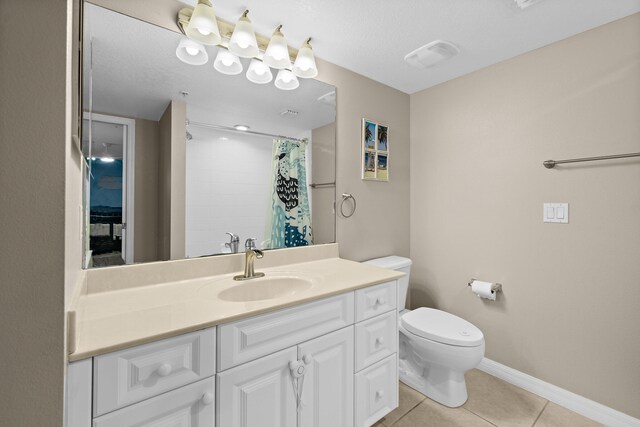 full bath with toilet, vanity, a shower with curtain, baseboards, and tile patterned floors