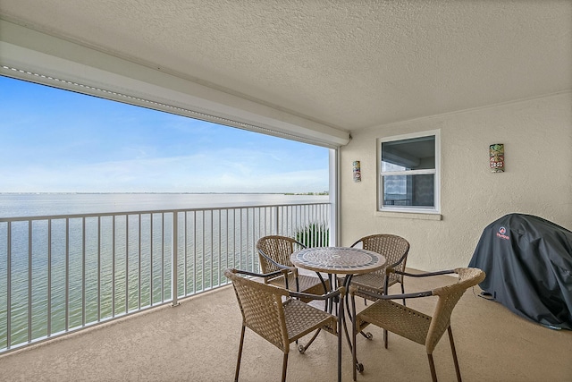 balcony with a water view and area for grilling