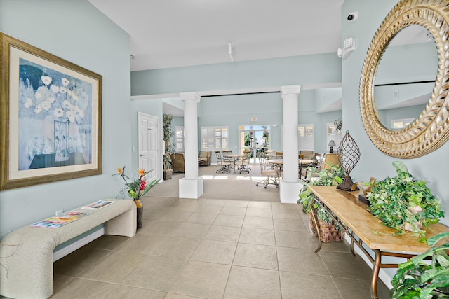 entrance foyer with light tile patterned floors and decorative columns