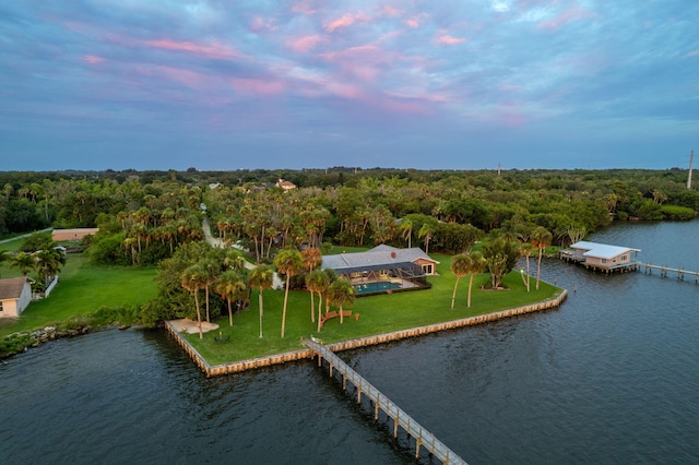 aerial view at dusk featuring a water view