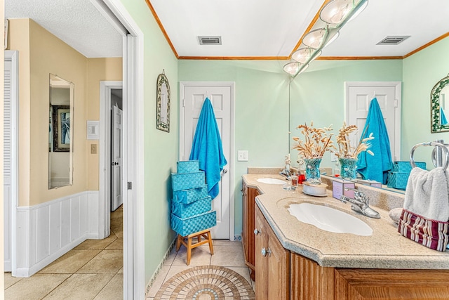 bathroom featuring tile patterned flooring, ornamental molding, and vanity