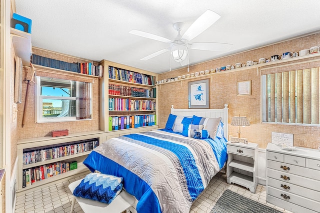 tiled bedroom featuring a textured ceiling and ceiling fan