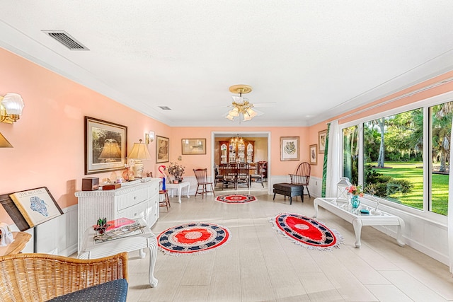 sitting room featuring ornamental molding and a chandelier