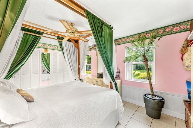 tiled bedroom featuring ceiling fan and a closet