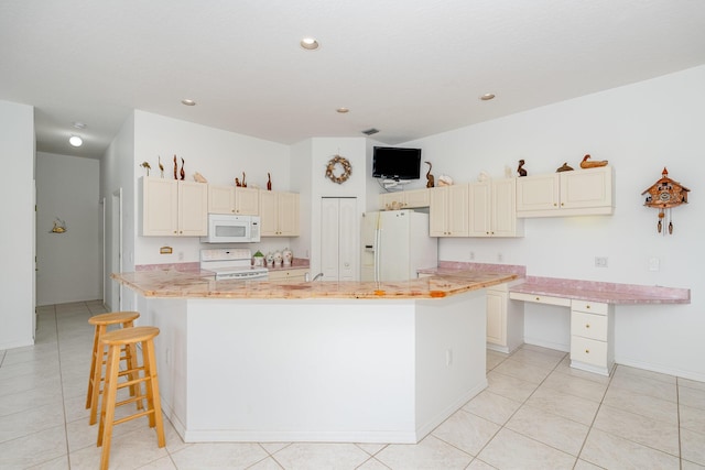 kitchen featuring light stone countertops, a center island, light tile patterned floors, and white appliances