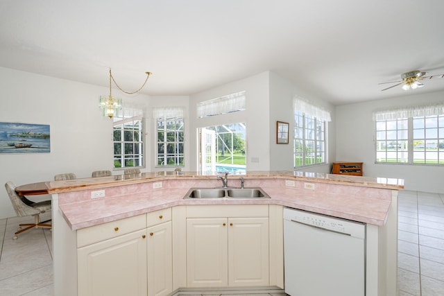 kitchen with a kitchen island with sink, white dishwasher, ceiling fan with notable chandelier, white cabinets, and sink