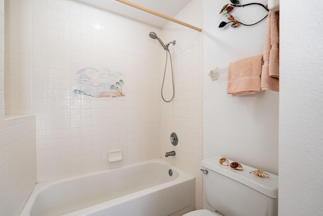 bathroom featuring toilet and tiled shower / bath