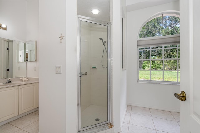 bathroom featuring tile patterned flooring, plenty of natural light, an enclosed shower, and vanity