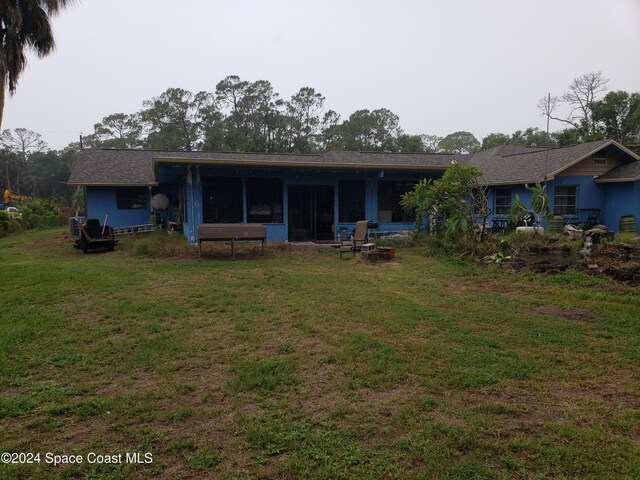 back of property featuring a yard and a sunroom