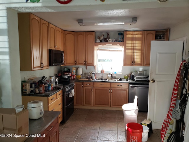 kitchen with light tile patterned flooring, sink, and black appliances