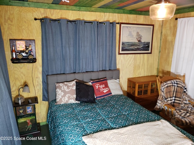 bedroom featuring wooden walls and wood ceiling