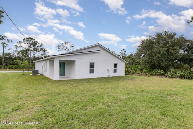 view of property exterior with a patio area, a yard, and central AC