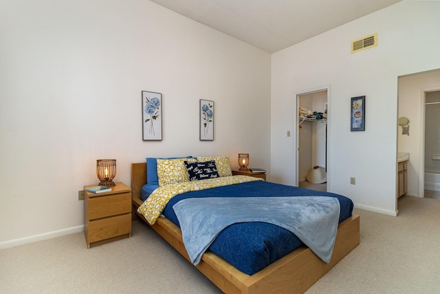 bedroom featuring a spacious closet, a closet, carpet, and ensuite bathroom