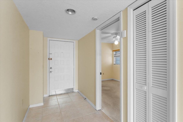 foyer with ceiling fan, light tile patterned floors, and a textured ceiling