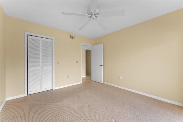 unfurnished bedroom featuring light carpet, a closet, and ceiling fan