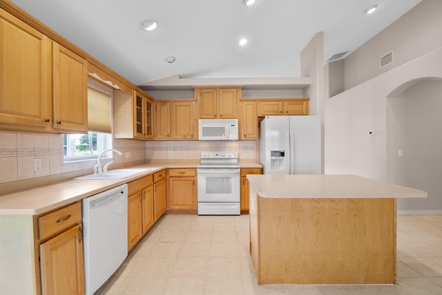 kitchen with a center island, white appliances, backsplash, sink, and vaulted ceiling