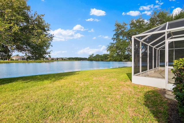 view of yard featuring glass enclosure and a water view